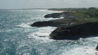 AX101_171E - 4.8K aerial stock footage of a domed rock formations in crystal blue waters along the coast, Arecibo, Puerto Rico