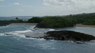 AX101_187 - 4.8K aerial stock footage Flying over trees, beaches and rock formations in crystal blue water, Manati, Puerto Rico 