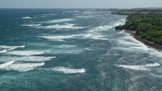 AX101_197E - 4.8K aerial stock footage of waves off of the coast in pristine blue water, Vega Baja, Puerto Rico