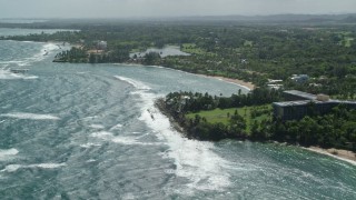 AX101_213 - 4.8K aerial stock footage of a Beachfront community along blue water, Dorado, Puerto Rico