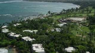 AX101_214E - 4.8K aerial stock footage of a beach and private resort along pristine blue waters, and coastal town in the distance, Dorado, Puerto Rico