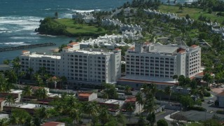 AX101_217E - 4.8K aerial stock footage flying over hotel toward condominiums on the coast, Dorado, Puerto Rico