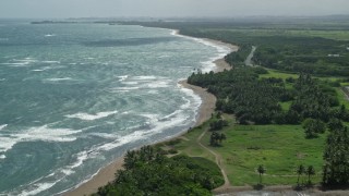 AX101_220E - 4.8K aerial stock footage following the beach over a lagoon on the coast, Dorado, Puerto Rico