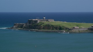 AX101_235 - 4.8K aerial stock footage of Fort San Felipe del Morro surrounded by crystal blue waters, Old San Juan Puerto Rico
