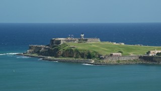AX101_235E - 4.8K aerial stock footage of Fort San Felipe del Morro surrounded by crystal blue waters, Old San Juan Puerto Rico