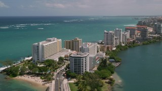 AX102_002 - 4.8K aerial stock footage of Hotels and high rises on the coast and crystal blue water, San Juan, Puerto Rico 