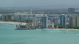 AX102_008 - 4.8K aerial stock footage of Apartment buildings on the coast and crystal blue waters, Carolina, Puerto Rico 