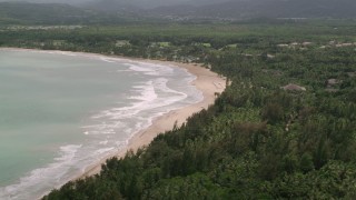 AX102_039 - 4.8K aerial stock footage of Turquoise waters along the beach approaching a resort, Rio Grande, Puerto Rico 
