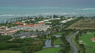 AX102_041E - 4.8K aerial stock footage of a golf resort along clear turquoise waters, Gran Melia Golf Resort, Puerto Rico