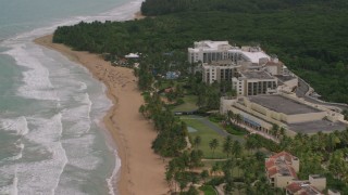 AX102_047 - 4.8K aerial stock footage of Sunbathers at the oceanfront Wyndham Grand Rio Mar Beach Resort and Spa, Rio Grande, Puerto Rico