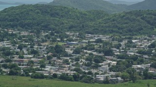 AX102_055E - 4.8K aerial stock footage of homes among tree covered hills, Fajardo, Puerto Rico