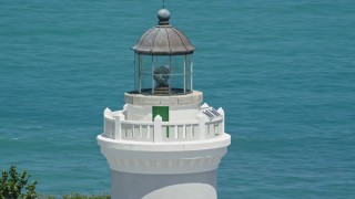 AX102_070 - 4.8K aerial stock footage Orbiting the top of Cape San Juan Light with views of clear blue waters, Puerto Rico