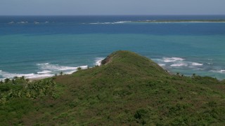 AX102_071 - 4.8K aerial stock footage Flying over a cliff to crystal clear blue water, Fajardo, Puerto Rico 