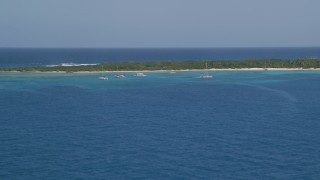 AX102_073 - 4.8K aerial stock footage of Catamarans near an island in tropical blue waters, Rada Fajardo, Puerto Rico