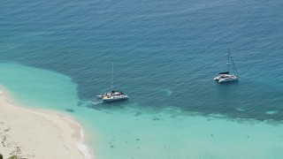 AX102_075 - 4.8K aerial stock footage of Catamarans in clear blue tropical waters, Rada Fajardo, Puerto Rico