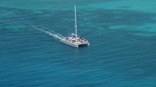 AX102_076 - 4.8K aerial stock footage Tracking a catamaran in crystal clear blue tropical waters, Rada Fajardo, Puerto Rico 