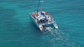 AX102_077 - 4.8K aerial stock footage Flying away from a catamaran in tropical blue water, Rada Fajardo, Puerto Rico