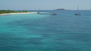 AX102_080 - 4.8K aerial stock footage of Catamarans in tropical blue waters, fly over white sand beach, Rada Fajardo, Puerto Rico 