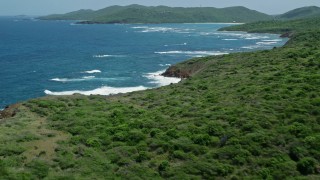 AX102_107E - 4.8K aerial stock footage of a Rugged coastline of a tree covered island in blue waters, Culebra, Puerto Rico