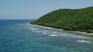 AX102_133E - 4.8K aerial stock footage of sapphire blue waters along a lush green coast, Culebra, Puerto Rico