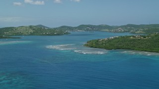 AX102_138E - 4.8K aerial stock footage of a hilltop home along sapphire blue waters, reveal coastal town, Culebra, Puerto Rico