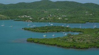AX102_141 - 4.8K aerial stock footage Orbiting sail boats in sapphire blue waters along tree covered coasts, Culebra, Puerto Rico