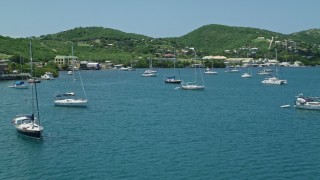 AX102_160E - 4.8K aerial stock footage of sailboats in sapphire blue waters near small town on the coast, Culebra, Puerto Rico