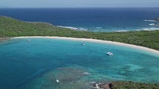 AX102_184 - 4.8K aerial stock footage of Catamarans in turquoise waters along a white sand Caribbean beach, Culebrita, Puerto Rico