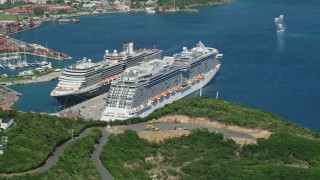 AX102_199 - 4.8K aerial stock footage of a Docked cruise ship in a coastal town in sapphire waters, Charlotte Amalie, St. Thomas