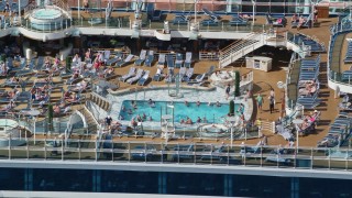 AX102_204 - 4.8K aerial stock footage of a Populated pool area on a cruise ship, Charlotte Amalie, St. Thomas