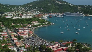 AX102_224 - 4.8K aerial stock footage of Sailboats and cruise ship in sapphire blue waters along a coastal town, Charlotte Amalie, St Thomas Day Sunny Side View