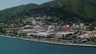 AX102_225E - 4.8K aerial stock footage of a coastal town between the hills and blue waters, Charlotte Amalie, St Thomas