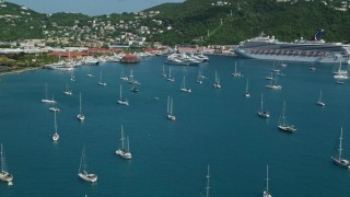 AX102_230 - 4.8K aerial stock footage of Sailboats and cruise ship in sapphire blue waters along the coast, Charlotte Amalie, St Thomas