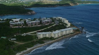 AX102_235E - 4.8K aerial stock footage of oceanfront condominiums on sapphire blue waters, Southside, St Thomas
