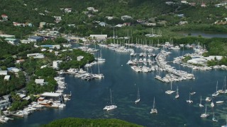 AX102_238E - 4.8K aerial stock footage of a marina with boats in blue ocean waters, Benner Bay, St Thomas