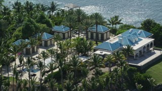 AX102_252E - 4.8K aerial stock footage of an oceanfront mansion and palm trees, Little St James Island, St Thomas