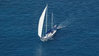 AX102_255E - 4.8K aerial stock footage of a sailboat in sapphire blue waters, St Thomas, USVI