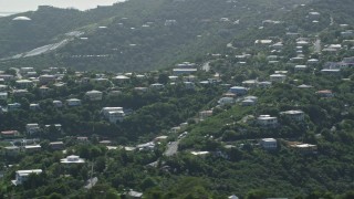 AX102_260 - 4.8K stock footage aerial video of Hilltop homes among trees, East End, St Thomas 
