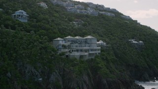 AX102_264 - 4.8K aerial stock footage of a Hillside oceanfront mansion with a pool, Northside, St Thomas 