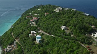 AX102_274E - 4.8K aerial stock footage of upscale, oceanfront hillside homes above turquoise Caribbean waters, Magens Bay, St Thomas