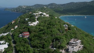 AX102_282 - 4.8K aerial stock footage of Oceanfront hillside homes along sapphire blue Caribbean waters, Magens Bay, St Thomas 