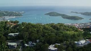 AX102_292 - 4.8K stock footage aerial video Reveal coastal town along turquoise blue Caribbean waters, Charlotte Amalie, St Thomas 