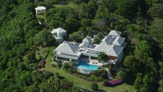 AX102_298 - 4.8K aerial stock footage of a Mansion nestled among trees, Charlotte Amalie, St Thomas 