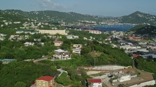 AX103_002 - 4.8K aerial stock footage Flying over homes in hills of coastal town, Charlotte Amalie, St Thomas
