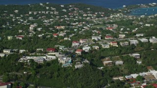 AX103_011E - 4.8K aerial stock footage of upscale homes on wooded hilltop, East End, St Thomas