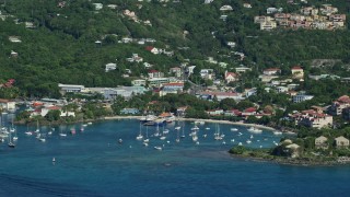 AX103_017E - 4.8K aerial stock footage of a coastal town and hillside homes along Caribbean blue waters, Cruz Bay, St John