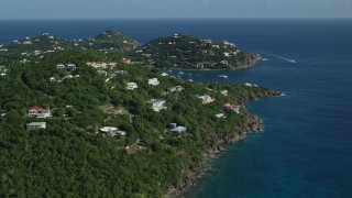 AX103_020 - 4.8K aerial stock footage of Hillside homes overlooking sapphire blue ocean waters, Cruz Bay, St John