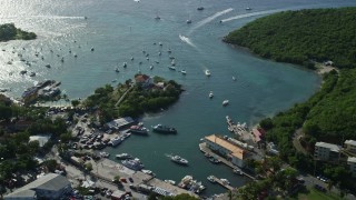 AX103_021E - 4.8K aerial stock footage of a fort and harbor with boats in turquoise blue Caribbean waters, Cruz Bay, St John