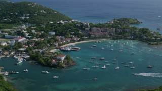 AX103_024 - 4.8K aerial stock footage of Grande Bay Resort in the Caribbean blue harbor waters with boats, Cruz Bay, St John