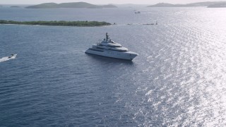 AX103_025 - 4.8K aerial stock footage of A yacht in sun kissed Caribbean waters among small islands, Cruz Bay, St John